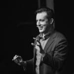 Jonathan W. Pritchard on stage in front of a corporate executive audience.