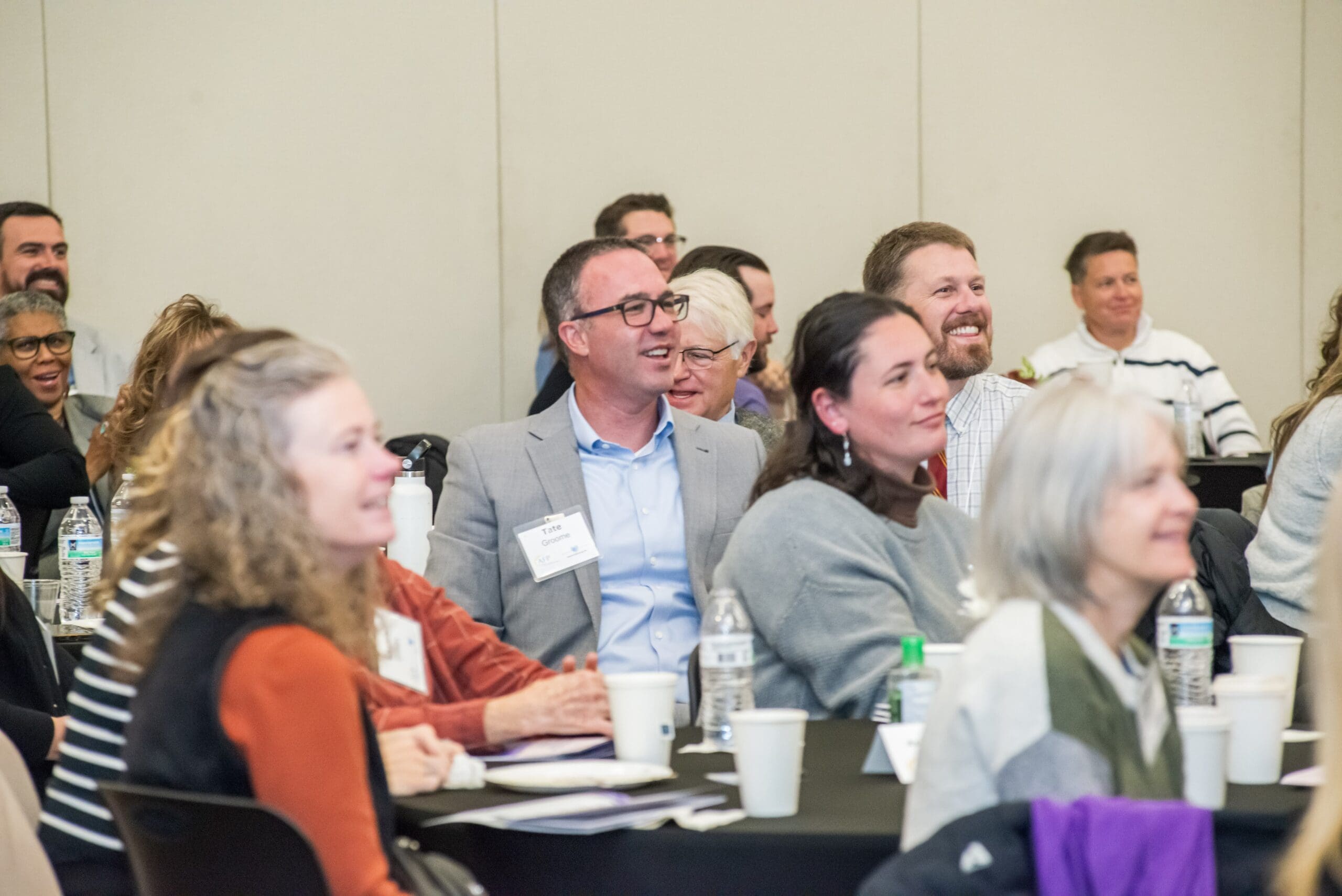 Jonathan W. Pritchard standing in front of a room full of professionals gathered to listen to him speak about the power of persuasion in high-stakes business.
